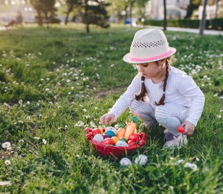 Mädchen mit einem Osternest auf einer Frühlingswiese