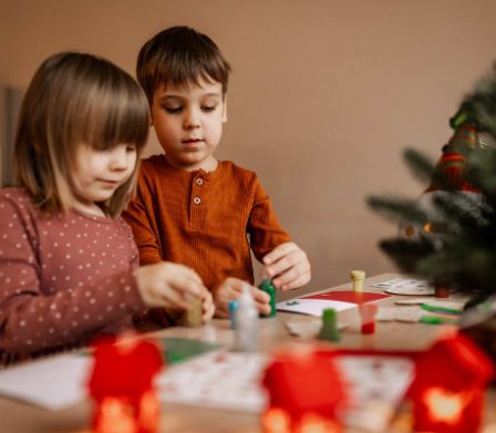 Zwei Geschwister basteln Weihnachtsgeschenke