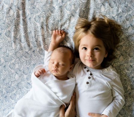 Jeune enfant et bébé sur un lit