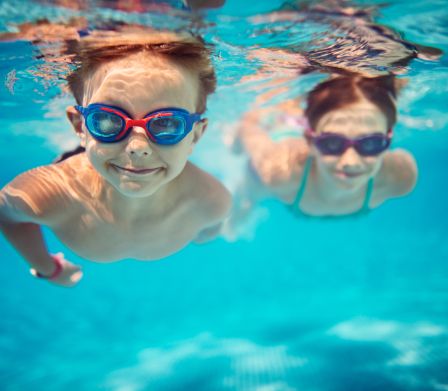 Foto subacquea di due ragazzi che nuotano sott'acqua