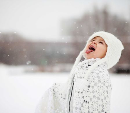 Mädchen streckt Zunge im Schnee raus