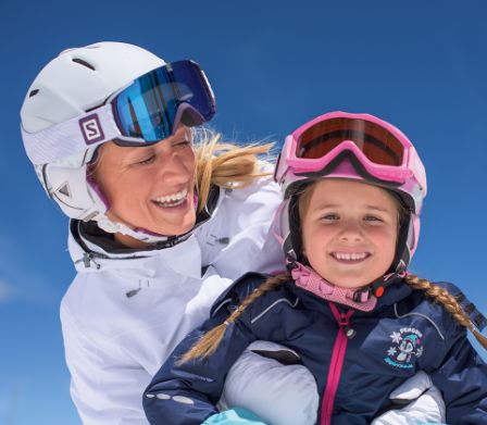 Mamma e figlia con casco e occhiali da sci