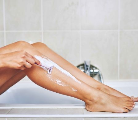 Enthaarung bei Teenager: Junge Frau am Beine rasieren