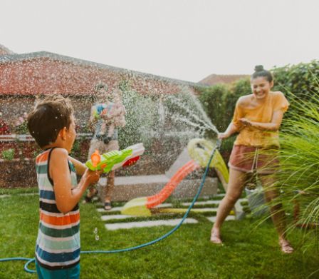 Una famiglia si diverte in giardino e gioca con l'acqua.