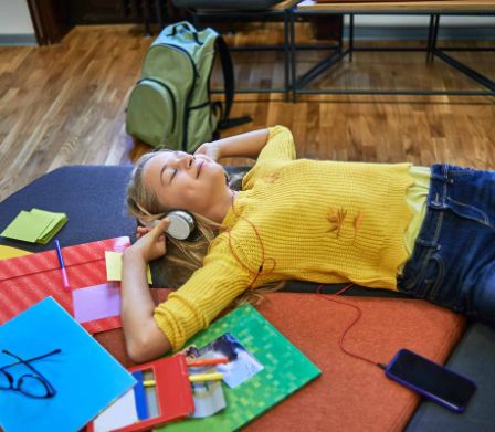 Une fille allongée par terre écoute de la musique