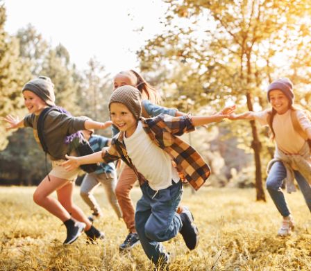 Kinder rennen über eine Wiese Kinder rennen über eine Wiese