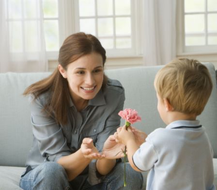 Un bimbo regala un fiore alla mamma