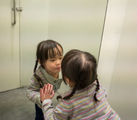Un bambino si osserva allo specchio