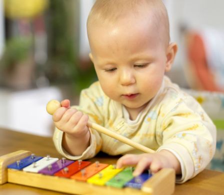 Un bebè suona uno xilofono giocattolo