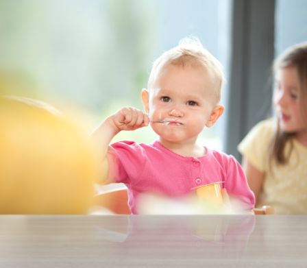 Bébé mangeant du séré aux fruits à la cuillère