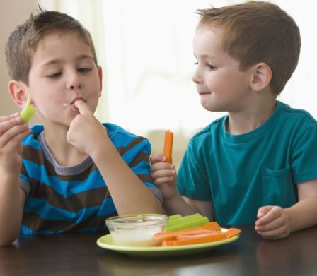 I bambini si gustano un piatto di verdure