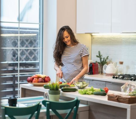 Schwangere bereitet Essen in der Küche zu