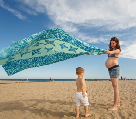 Schwangere Mutter mit Bub an einem Strand am Meer