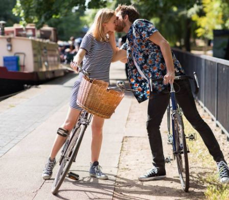 Una coppia mentre si bacia in bicicletta
