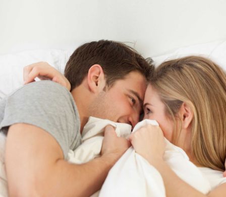Un couple couché dans un lit se regarde mutuellement