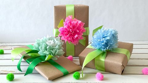 La fleur en papier de soie comme décoration colorée sur un emballage cadeau