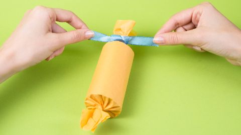 Chiudere le estremità della carta velina con dei nastri regalo.