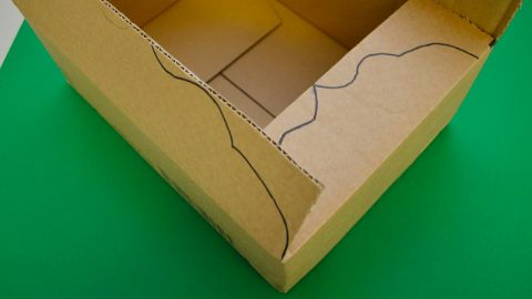Une boîte en carton avec des motifs de vagues peints à la main