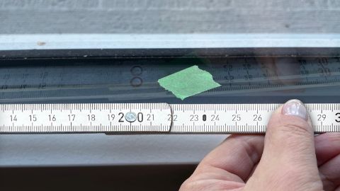 La finestra viene misurata e il centro viene segnato con un pezzo di nastro adesivo
