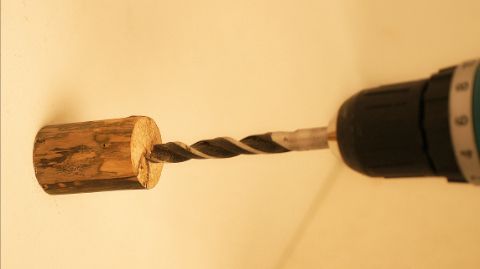 Fare una piccola incisione con il trapano nella parte centrale superiore di un pezzo di legno