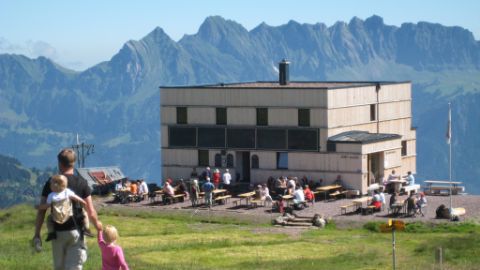 SAC Hütte mit Gästen auf grosser Terrasse
