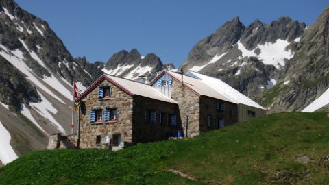 Grande cabane CAS devant des versants montagneux enneigés