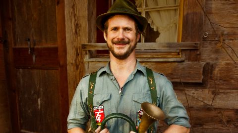 Mann in Tracht mit Blasinstrument Mann in Tracht mit Blasinstrument