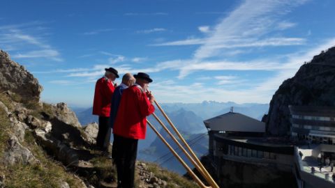 Suonatori di corno alpino davanti a una stazione di montagna Suonatori di corno alpino davanti a una stazione di montagna