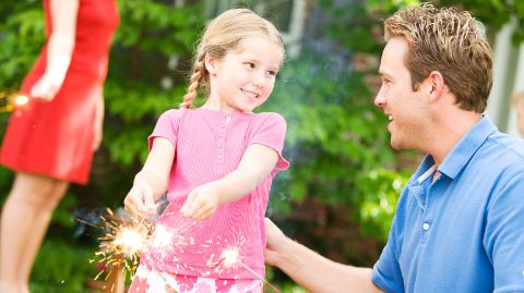 Padre e bambina con candele magiche all'aperto Padre e bambina con candele magiche all'aperto