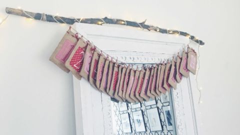 Sacchettini del calendario dell’Avvento appesi a un ramo Sacchettini del calendario dell’Avvento appesi a un ramo