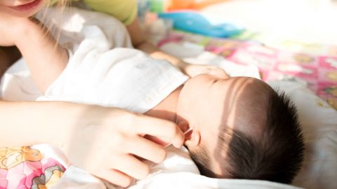 Maman nettoyant les oreilles de son bébé Maman nettoyant les oreilles de son bébé