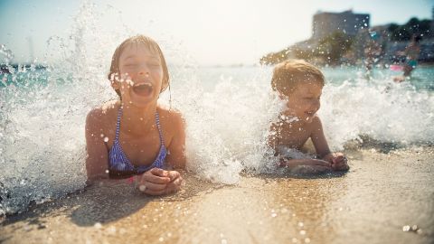 Des enfants sont couchés dans l’eau sur une plage Des enfants sont couchés dans l’eau sur une plage