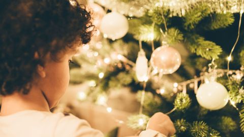 Bambino piccolo che addobba l’albero di Natale